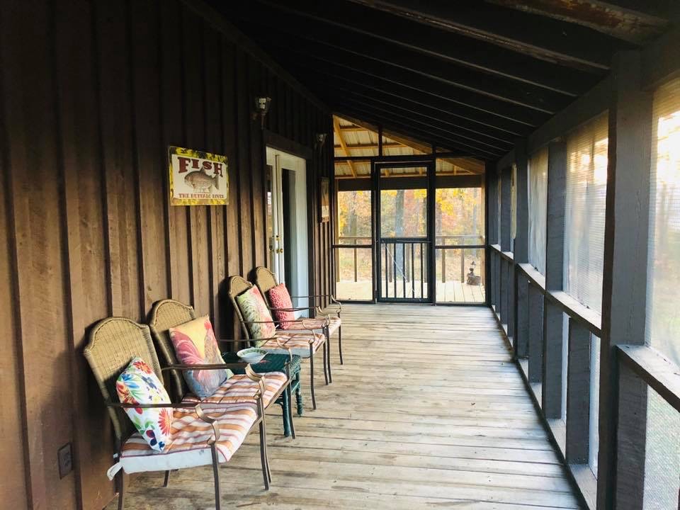 Screen porch at tree top level on hunting and fishing vacation cabin.