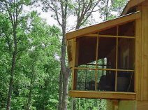 Screen porch at tree top level on hunting and fishing vacation cabin.